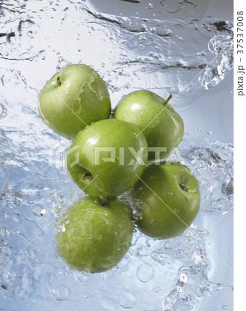 Five Granny Smith apples dropping into water 37537008