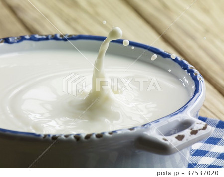 Milk splashing out of a bowl 37537020