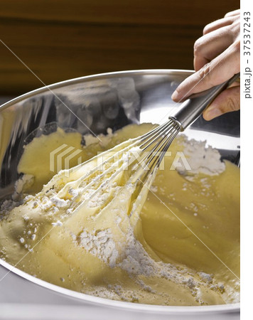 Preparing sponge mix: fold flour into egg mixture Preparing sponge mix: fold flour into egg mixture 37537243
