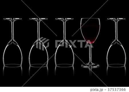 Row of wine glasses and a glass of red wine against a black background Row of wine glasses and a glass of red wine against a black background 37537366