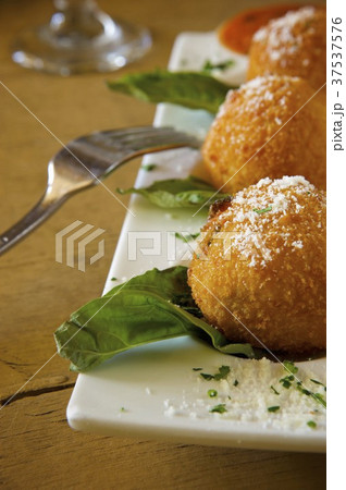 Deep Fried Risotto Balls on a Platter with Parmesan Cheese 37537576