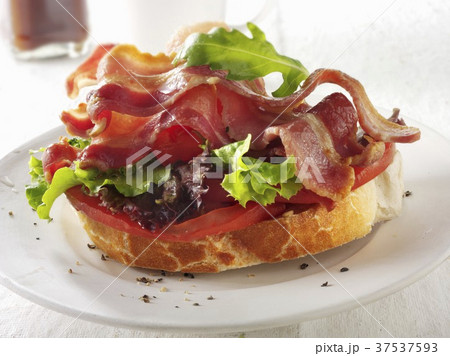 A slice of baguette topped with bacon, lettuce and tomato 37537593