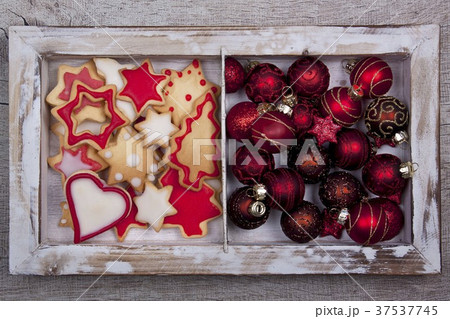 Christmas cookies and Christmas tree ball ornaments in a wooden frame Christmas cookies and Christmas tree ball ornaments in a wooden frame 37537745