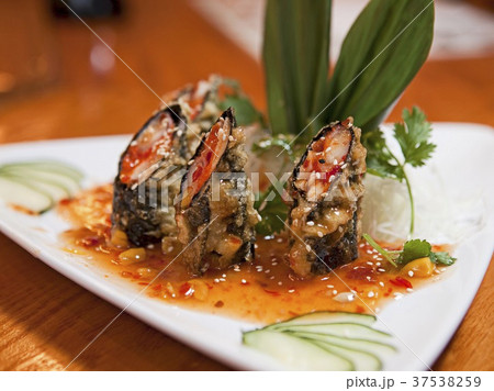 Tuna and Salmon Tempura Seaweed Wraps in a Sesame Sauce on a White Plate 37538259
