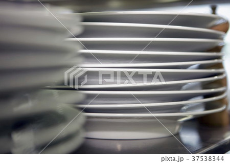 A stack of plates in a commercial kitchen 37538344