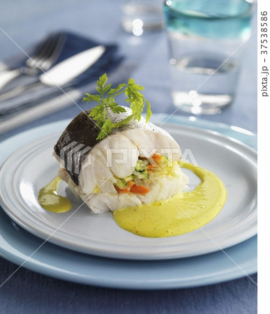 Hake filled with vegetables and served with saffron sauce Hake filled with vegetables and served with saffron sauce 37538586