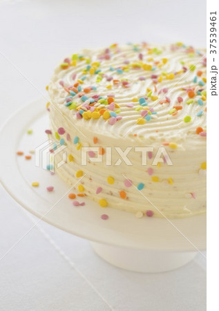 An orange and pineapple cake topped with cream cheese and decorated with sugar confetti An orange and pineapple cake topped with cream cheese and decorated with sugar confetti 37539461