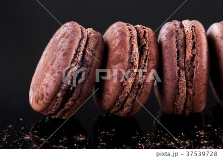 A row of chocolate macaroons 37539728