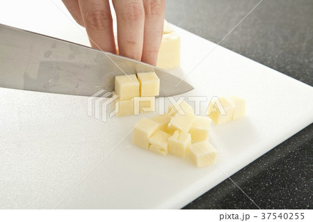 Hands Cutting Cheddar Cheese Into Cubes 37540255