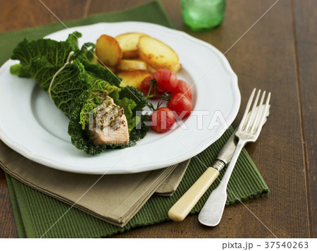 Salmon wrapped in savoy cabbage with fried potatoes and cherry tomatoes 37540263