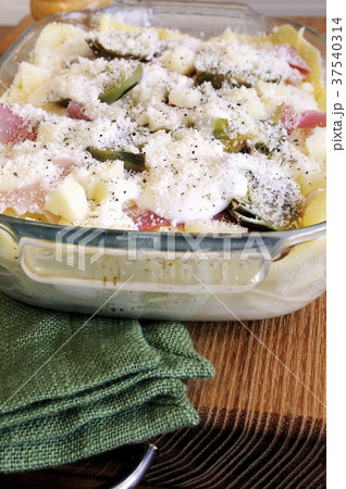 Unbaked lasagne with artichokes and ham in a baking dish 37540314