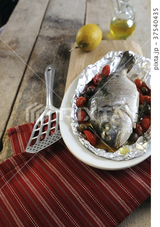 Oven roasted porgy wrapped in foil with cherry tomatoes and olives 37540435