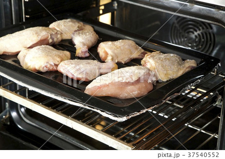 Chicken Pieces on a Roasting Pan Going into the Oven Chicken Pieces on a Roasting Pan Going into the Oven 37540552