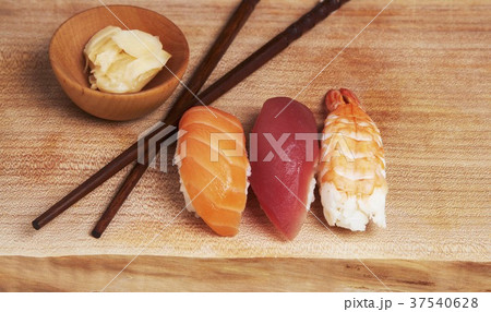 Sashimi Sushi (Salmon, Tuna, Shrimp) on Wood Board with Ginger and Chopsticks 37540628