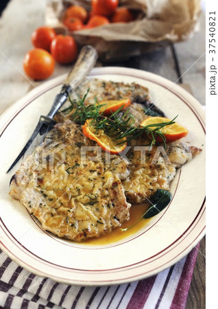 Breaded pork chops with an orange and rosemary sauce Breaded pork chops with an orange and rosemary sauce 37540821
