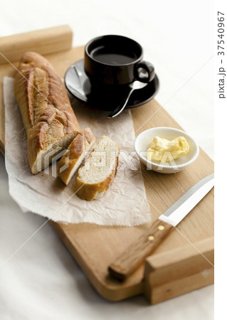 Partially Slices Baguette with Butter and a Cup of Coffee Partially Slices Baguette with Butter and a Cup of Coffee 37540967