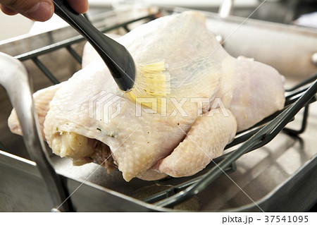 Brushing a Whole Roast Chicken with Butter 37541095
