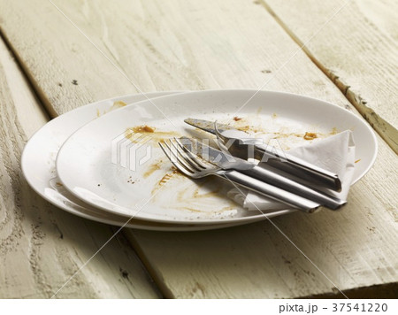 A dirty plate with cutlery and a paper napkin A dirty plate with cutlery and a paper napkin 37541220