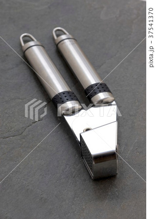 A garlic press on a slate surface A garlic press on a slate surface 37541370