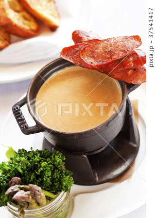 A fondue made with gouda and porter cheese with Andouille sausage, broccolini and asparagus 37541417