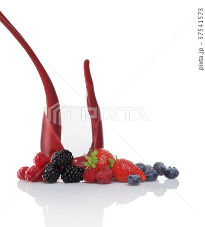 A splash of fruits of the forest juice in a glass surrounded by fruits of the forest 37541573