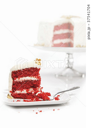 Slice of Red Velvet Cake On a Plate with Whole Cake in Background 37541704