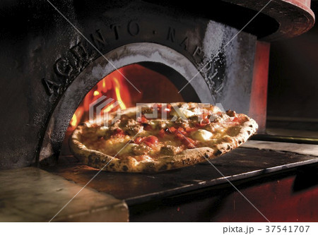 Pizza In Front of a Wood Fired Oven 37541707