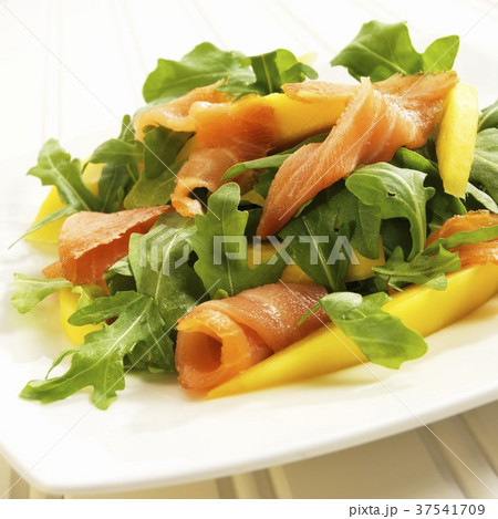 Arugula Salad with Salmon and Mango on a White Plate 37541709