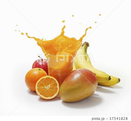 A splash of juice in a glass surrounded by oranges, bananas, mango and apple 37541828
