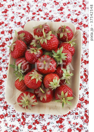 Fresh strawberries in a dish on a floral tablecloth 37542548