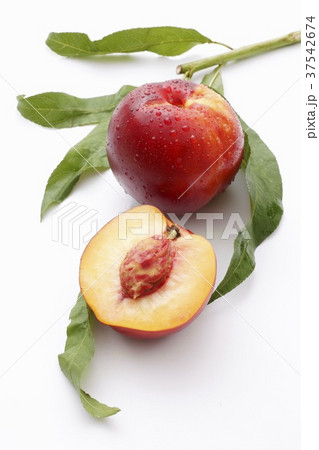 A whole nectarine and half a nectarine with leaves 37542674