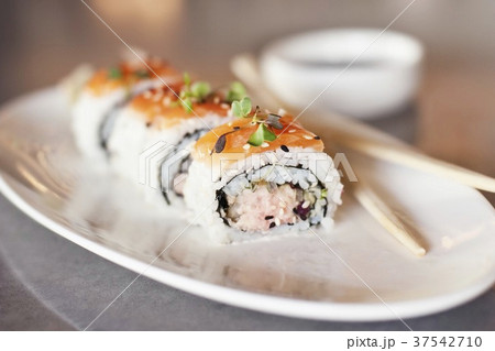 Spicy Tuna and Salmon Sushi Roll on a White Plate; Chopsticks Spicy Tuna and Salmon Sushi Roll on a White Plate; Chopsticks 37542710