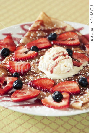 Crepe Topped with Fresh Strawberries and Blueberries and a Scoop of Ice Cream Crepe Topped with Fresh Strawberries and Blueberries and a Scoop of Ice Cream 37542713