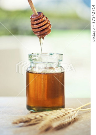 Jar of honey with honey dipper 37542714