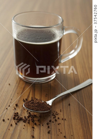 A cup of instant coffee and a spoonful of instant coffee powder 37542760