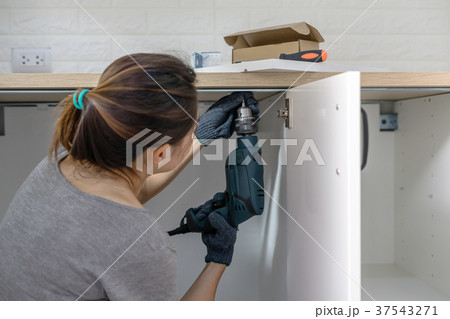 Young woman using electric screwdriver Young woman using electric screwdriver 37543271