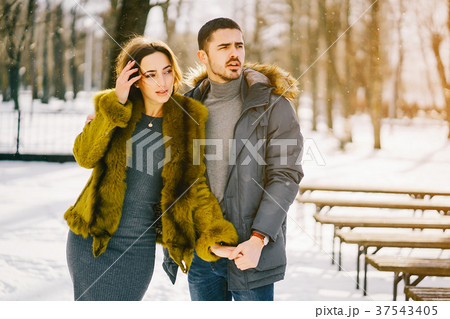 happy couple walking through the park on a sunny 37543405