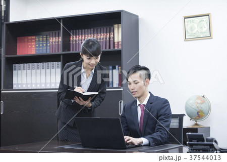 パソコンを見ながら打ち合わせする若い社長と秘書 パソコンを見ながら打ち合わせする若い社長と秘書 37544013