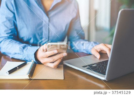 Business woman hand uses a mobile phone. 37545129