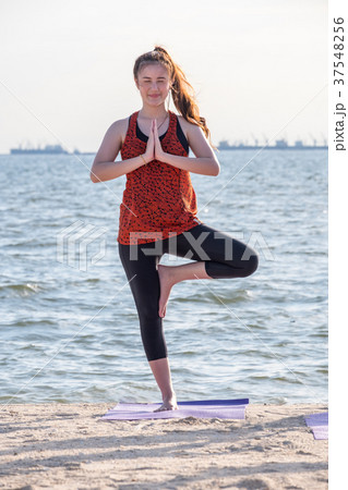 Asia woman doing tree pose and namaste with calm 37548256