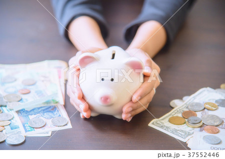 Piggy bank in hand with cash pile. 37552446