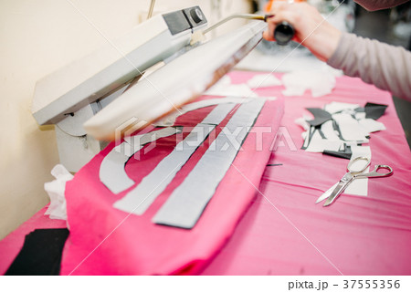 Clothes designer works on steam press 37555356