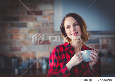 woman with cup of coffee or tea at kitchen 37556890
