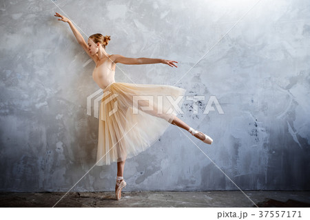 Young ballerina in golden costume posing in studio 37557171