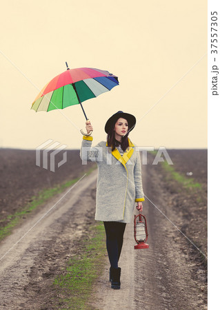 Woman with lamp and umbrella at countryside 37557305
