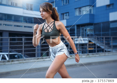 Long haired sporty girl exercises on city street 37557869
