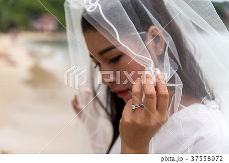 The bride in a white veil wears a wedding ring The bride in a white veil wears a wedding ring 37558972