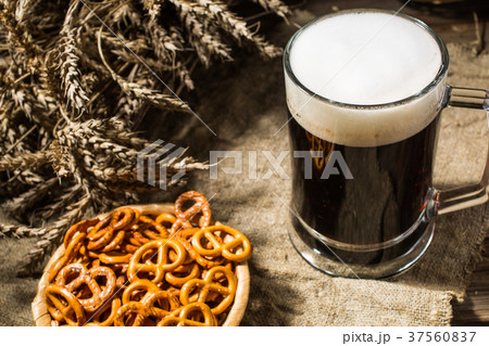Mug beer with wheat and basket of pretzels on 37560837