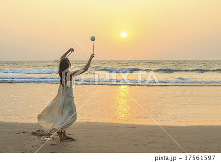 Unidentified woman spinning poi on the beach. 37561597
