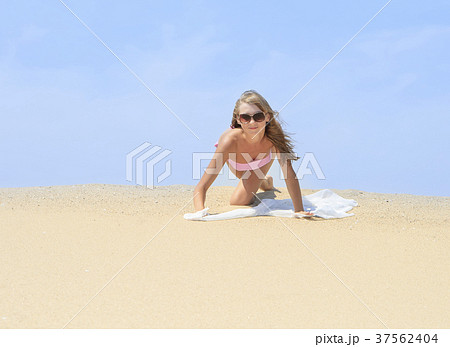 Tanned young female relaxing on the beach Tanned young female relaxing on the beach 37562404